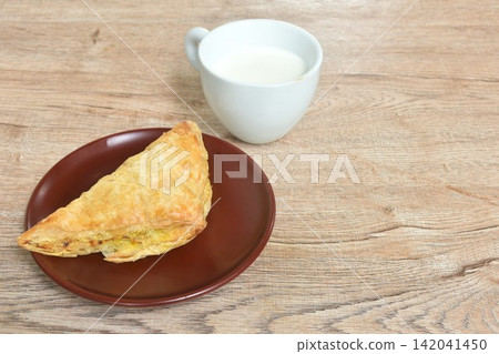 salty chicken curry pie on plate with fresh milk cup salty chicken curry pie on plate with fresh milk cup 142041450