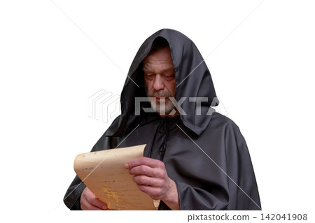 Elderly monk in black hooded robe reading parchment on white Elderly monk in black hooded robe reading parchment on white 142041908