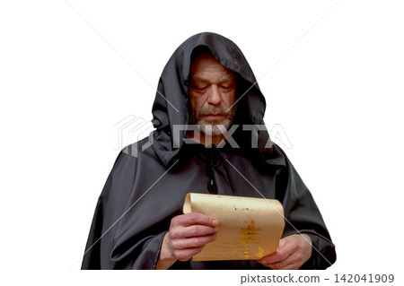 Serious monk in black hood reading old parchment isolated on white Serious monk in black hood reading old parchment isolated on white 142041909
