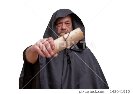 Serious hooded monk holding rolled parchment toward camera isolated on white Serious hooded monk holding rolled parchment toward camera isolated on white 142041910