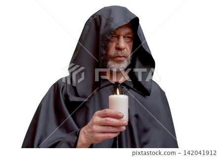 Serious bearded monk in black hood holding candle isolated portrait Serious bearded monk in black hood holding candle isolated portrait 142041912