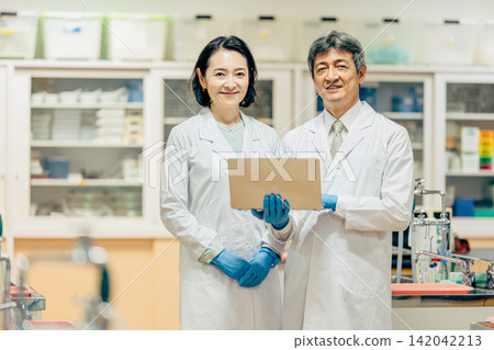 在實驗室中使用顯微鏡進行研究的研究人員 在實驗室中使用顯微鏡進行研究的研究人員 142042213