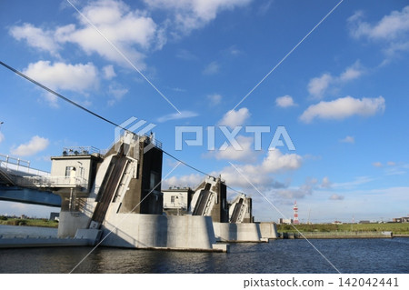The Gyotoku Movable Weir, a massive infrastructure supporting flood control and water utilization, under the blue sky. The Gyotoku Movable Weir, a massive infrastructure supporting flood control and water utilization, under the blue sky. 142042441