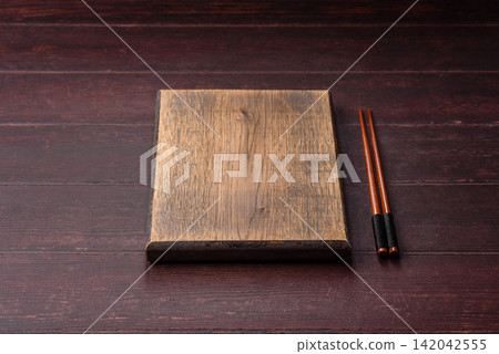 A square wooden cutting board for home food preparation. A wooden cutting board A square wooden cutting board for home food preparation. A wooden cutting board 142042555
