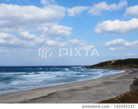 種子島上美麗的沙灘,藍天下,白色的海浪拍打著海岸。 種子島上美麗的沙灘,藍天下,白色的海浪拍打著海岸。 142043237