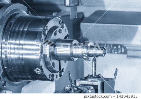 Mass production of high precision metal parts by multi-tasking CNC lathe machine in blue tone lighting Mass production of high precision metal parts by multi-tasking CNC lathe machine in blue tone lighting 142043915