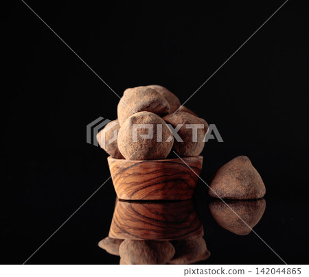 Chocolate truffles in small wooden dish. Chocolate truffles in small wooden dish. 142044865