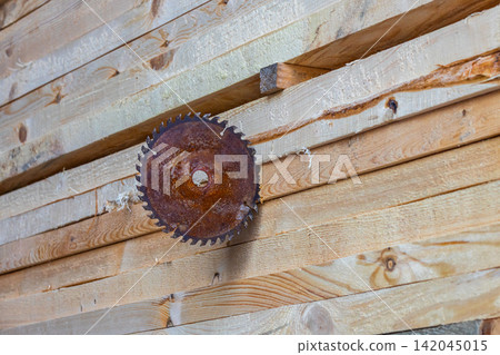 Rusty Circular Saw Blade Resting on Stacked Lumber Rusty Circular Saw Blade Resting on Stacked Lumber 142045015