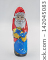 Chocolate Santa Claus wrapped in foil closeup on white. 142045083