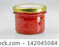 Glass jar of red caviar on a white background, closeup. 142045084