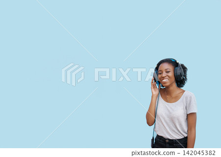 Music, portrait and black woman with headphones in studio for sound, track or listening to podcast on blue background. Streaming, mockup or gen z African student with radio, playlist or audio ebook Music, portrait and black woman with headphones in studio for sound, track or listening to podcast on blue background. Streaming, mockup or gen z African student with radio, playlist or audio ebook 142045382