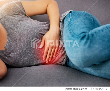 Stomach pain, hands or girl on sofa with pms glow, endometriosis or gut health crisis at home. Uterus, virus or colon emergency in living room for period, gas or constipation, disaster and fibroids 142045397