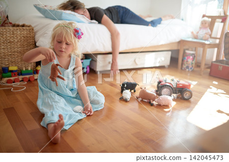 Tired mom, sleeping and girl playing with toys on floor lonely, neglect and fatigue at home. Parenting, fail and mother with insomnia in bed for afternoon nap in house with curious bored daughter Tired mom, sleeping and girl playing with toys on floor lonely, neglect and fatigue at home. Parenting, fail and mother with insomnia in bed for afternoon nap in house with curious bored daughter 142045473