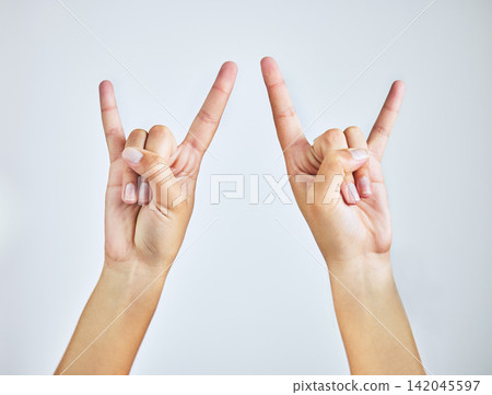 Hands, closeup and person in studio with rock and roll sign, gesture or symbol on white background. Zoom, rebel and icon with rocker emoji for edgy, cool or contemporary, metal or punk aesthetic Hands, closeup and person in studio with rock and roll sign, gesture or symbol on white background. Zoom, rebel and icon with rocker emoji for edgy, cool or contemporary, metal or punk aesthetic 142045597