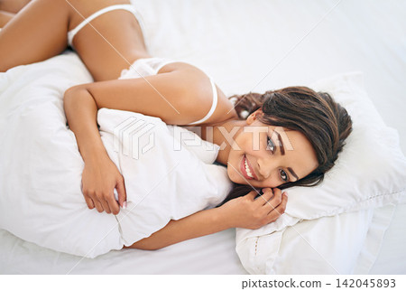 Lingerie, portrait and woman lying in bed for fashion, underwear and sexy clothing in apartment. Attractive, above view and female person in bedroom for confidence, smile and comfortable in morning Lingerie, portrait and woman lying in bed for fashion, underwear and sexy clothing in apartment. Attractive, above view and female person in bedroom for confidence, smile and comfortable in morning 142045893