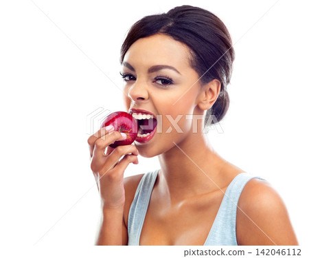 Black woman, health and eating into an apple for nutrition and weight loss program isolated in studio. Female person or model and fruit for lunch, balanced diet and wellness with white background Black woman, health and eating into an apple for nutrition and weight loss program isolated in studio. Female person or model and fruit for lunch, balanced diet and wellness with white background 142046112