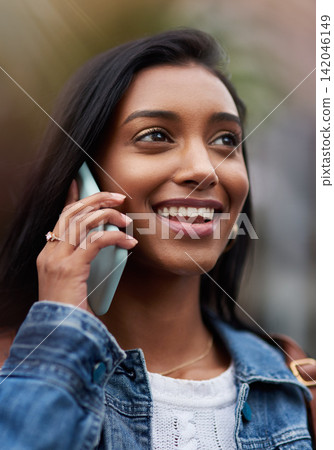 Indian, woman and phone call for communication outdoor, conversation and technology with travel. Contact, digital connection and virtual chat with talking on commute in city, mobile app and VOIP Indian, woman and phone call for communication outdoor, conversation and technology with travel. Contact, digital connection and virtual chat with talking on commute in city, mobile app and VOIP 142046149
