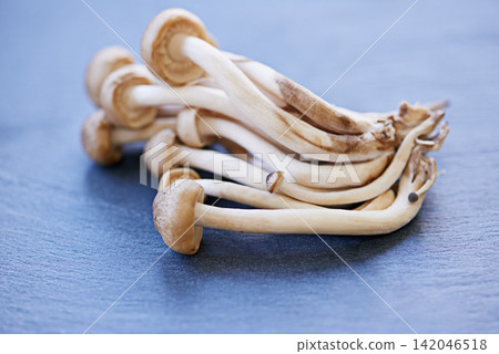Beech mushrooms, board and preparing in closeup with fibre for protein in healthy diet with vegetables for cooking. Vitamin b, nutrition and vegetable with groceries, eating and organic for health Beech mushrooms, board and preparing in closeup with fibre for protein in healthy diet with vegetables for cooking. Vitamin b, nutrition and vegetable with groceries, eating and organic for health 142046518