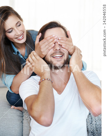Cover, eyes and couple with happy surprise in home and game with fun reveal or announcement. Guess, who and partner with hands on face to hide secret, news or woman playing prank in marriage Cover, eyes and couple with happy surprise in home and game with fun reveal or announcement. Guess, who and partner with hands on face to hide secret, news or woman playing prank in marriage 142046558