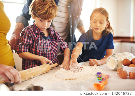 Family, baking and kitchen for fun with learning with child development. Parents, kids and childhood on weekend for bonding with mess at home on table for memories with cookies, children and happy Family, baking and kitchen for fun with learning with child development. Parents, kids and childhood on weekend for bonding with mess at home on table for memories with cookies, children and happy 142046722