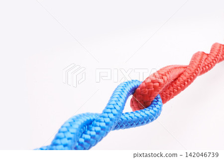 Rope, ties and connection with color in knot, link or loop together on white background in collaboration. Blue, red and join string in abstract unity with security from contact in chain or coil Rope, ties and connection with color in knot, link or loop together on white background in collaboration. Blue, red and join string in abstract unity with security from contact in chain or coil 142046739