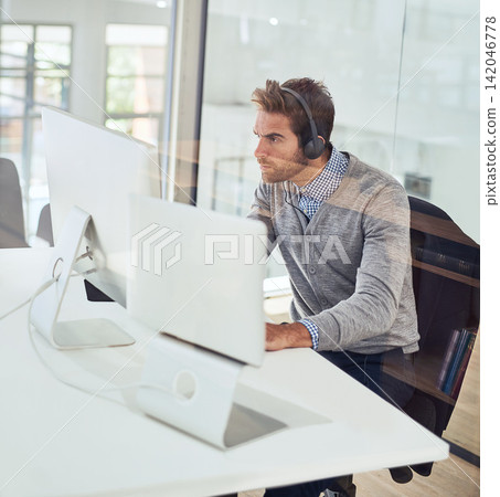 Office, monitor and serious businessman with headphones for audio, streaming and listening to music. Male person, administration and work with technology for portfolio research, report and feedback Office, monitor and serious businessman with headphones for audio, streaming and listening to music. Male person, administration and work with technology for portfolio research, report and feedback 142046778