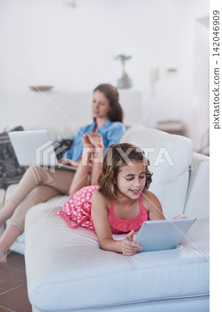 Mother, child and tablet or laptop in home for online streaming for entertainment, movie or internet. Woman, daughter and connectivity on sofa or relax together in living room, games or subscription 142046909