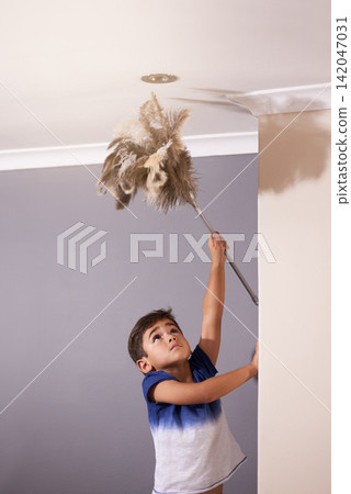 Child, dusting and ceiling in house for spring cleaning, learning responsibility and development. Young boy, kid or children and reaching light for busy routine, childhood and cute in dusty home Child, dusting and ceiling in house for spring cleaning, learning responsibility and development. Young boy, kid or children and reaching light for busy routine, childhood and cute in dusty home 142047031