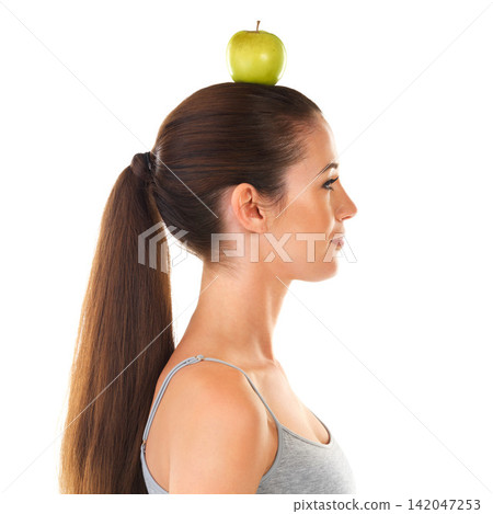 Woman, apple and balance on head for health, nutrition and wellness as fruit for diet on studio backdrop in profile. Female person, food and benefits of organic, fiber and vitamin C for skincare Woman, apple and balance on head for health, nutrition and wellness as fruit for diet on studio backdrop in profile. Female person, food and benefits of organic, fiber and vitamin C for skincare 142047253