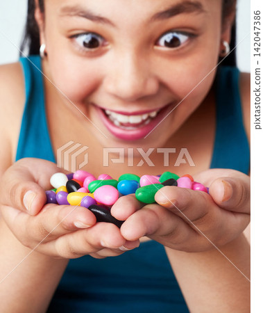 Girl, candy in hands and happy with snack for reward or bonus, shock or omg with winner of junk food. Sweets, jelly beans and excited kid for prize with joy, surprise or wow reaction with confection Girl, candy in hands and happy with snack for reward or bonus, shock or omg with winner of junk food. Sweets, jelly beans and excited kid for prize with joy, surprise or wow reaction with confection 142047386