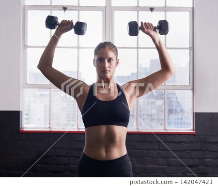 Fitness, dumbbells and woman in portrait for workout, training and strength for core muscle in gym. Female athlete, physical activity or exercise with balance, endurance or commitment in sports Fitness, dumbbells and woman in portrait for workout, training and strength for core muscle in gym. Female athlete, physical activity or exercise with balance, endurance or commitment in sports 142047421