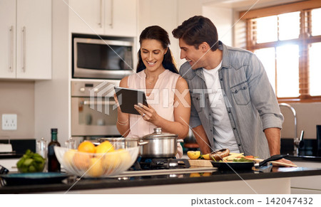 Couple, kitchen and cooking with online video on tablet, wellness and nutrition. Marriage, man and woman cut or read instructions on the internet, food website or blog and prepare meal for dinner Couple, kitchen and cooking with online video on tablet, wellness and nutrition. Marriage, man and woman cut or read instructions on the internet, food website or blog and prepare meal for dinner 142047432