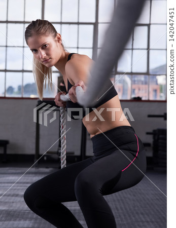 Fitness, woman and pull rope in gym for power workout, grip strength or intense cardio exercise. Sports, athlete and female person with tug of war for performance, muscle endurance or arm training Fitness, woman and pull rope in gym for power workout, grip strength or intense cardio exercise. Sports, athlete and female person with tug of war for performance, muscle endurance or arm training 142047451