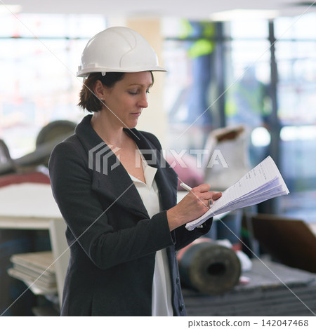 Construction, document and serious woman or architect writing notes for industrial building development project manager. Paperwork, engineer and builder on checklist for planning maintenance at site Construction, document and serious woman or architect writing notes for industrial building development project manager. Paperwork, engineer and builder on checklist for planning maintenance at site 142047468