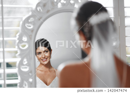Bride, wedding and smile on mirror for reflection, happy and prepare for ceremony celebration. Marriage, client and woman at salon or boutique for fabric sale, elegant white dress and classy makeup Bride, wedding and smile on mirror for reflection, happy and prepare for ceremony celebration. Marriage, client and woman at salon or boutique for fabric sale, elegant white dress and classy makeup 142047474