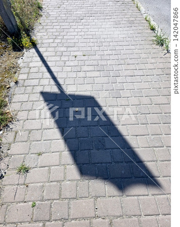 Charming Cobblestones Adorned With Green Grass and Vivid Shadows on a Sunny Day Charming Cobblestones Adorned With Green Grass and Vivid Shadows on a Sunny Day 142047866