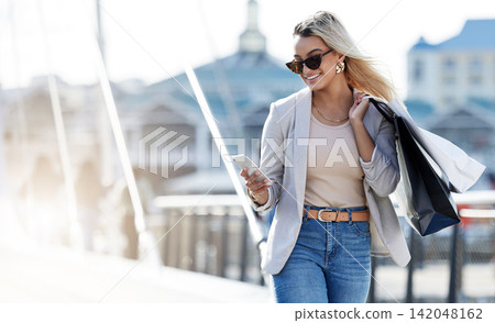 Outdoor, smartphone and woman with bags, shopping or promotion with luxury products, New York or discount deal. Person, consumer and girl with sale, cellphone or fashion in urban town with retail Outdoor, smartphone and woman with bags, shopping or promotion with luxury products, New York or discount deal. Person, consumer and girl with sale, cellphone or fashion in urban town with retail 142048162