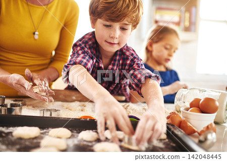 Family, kitchen and baking for fun with learning with child development. Mom, kids and childhood on weekend for bonding with mess at home on table for memories with cookies, happy and children Family, kitchen and baking for fun with learning with child development. Mom, kids and childhood on weekend for bonding with mess at home on table for memories with cookies, happy and children 142048445