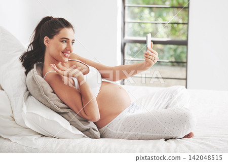 Pregnant woman, phone selfie or video call in home bedroom for communication or online consultation. Wave, mom or happy mother with mobile app for gynecology telehealth, pregnancy update or maternity Pregnant woman, phone selfie or video call in home bedroom for communication or online consultation. Wave, mom or happy mother with mobile app for gynecology telehealth, pregnancy update or maternity 142048515