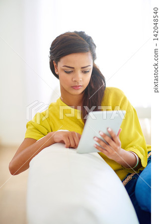 Woman, tablet and home on couch for e learning, fun or online with chat, social media and streaming. Female person, house and relax for break, communication and internet with tech, typing or browsing Woman, tablet and home on couch for e learning, fun or online with chat, social media and streaming. Female person, house and relax for break, communication and internet with tech, typing or browsing 142048540