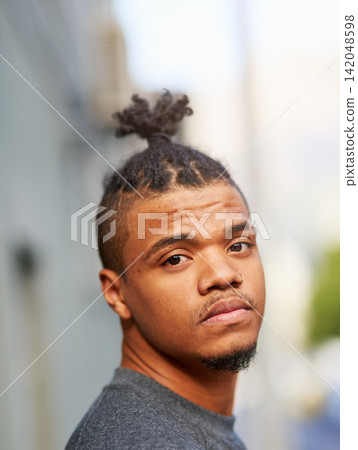 Portrait, black man and cool or funky hairstyle in city with topknot and braided hair for barbershop. Creative, unconventional and serious african person, face or identity expression with urban style Portrait, black man and cool or funky hairstyle in city with topknot and braided hair for barbershop. Creative, unconventional and serious african person, face or identity expression with urban style 142048598