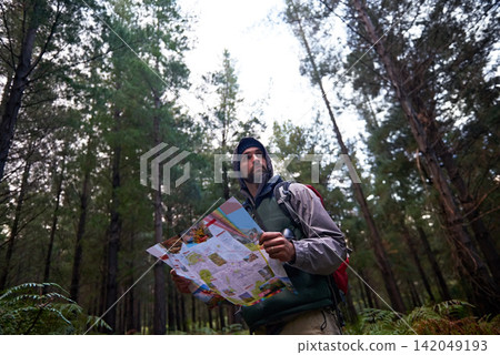 Lost, man and search forest with map as guide to camp in woods and thinking of navigation or direction. Confused, travel and trekking in nature with backpack and plan to location on hiking journey Lost, man and search forest with map as guide to camp in woods and thinking of navigation or direction. Confused, travel and trekking in nature with backpack and plan to location on hiking journey 142049193