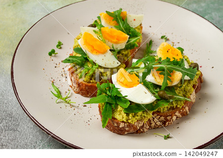 sandwich with mashed avocado, boiled egg, and arugula, on bread , homemade, breakfast, sandwich with mashed avocado, boiled egg, and arugula, on bread , homemade, breakfast, 142049247