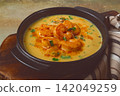 Creamy shrimp curry with spices, garnished with herbs, on a textured background, homemade , no people, 142049259