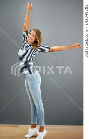 Woman, happy and home fashion or relax, casual and carefree or stretch for freedom and smile. Standing, grey wall and portrait in jeans with confident girl, weekend and comfort style or outfit Woman, happy and home fashion or relax, casual and carefree or stretch for freedom and smile. Standing, grey wall and portrait in jeans with confident girl, weekend and comfort style or outfit 142049285