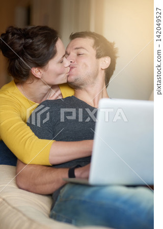 Couple, kiss and laptop on sofa with love or bonding for romance with streaming videos, comedy shows and online. Man, woman and relax together in home with digital technology for movies and happiness Couple, kiss and laptop on sofa with love or bonding for romance with streaming videos, comedy shows and online. Man, woman and relax together in home with digital technology for movies and happiness 142049527