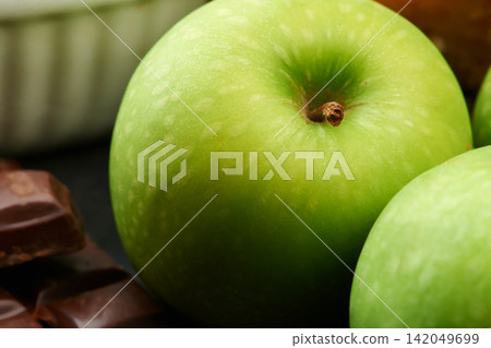 Closeup, healthy or apple for diet in kitchen of home on counter for diet, natural vitamin c or nutrition. Vegan, background or fruit with sweet chocolate in apartment or house for detox or minerals Closeup, healthy or apple for diet in kitchen of home on counter for diet, natural vitamin c or nutrition. Vegan, background or fruit with sweet chocolate in apartment or house for detox or minerals 142049699