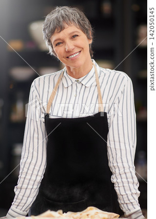 Chef, bakery and portrait of mature woman with smile, apron and cooking for meal prep with confidence. Lunch, nutrition and happy face of baker at kitchen counter for pride, small business and pastry 142050145
