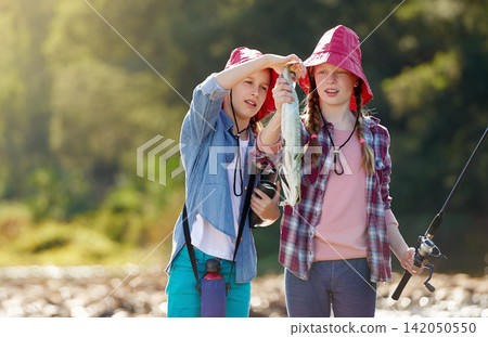 Countryside, children or caught fish in river on holiday break, vacation or adventure as hobby or activity. Sunshine, girls or siblings and fishing rod in water on weekend trip, outdoor and nature Countryside, children or caught fish in river on holiday break, vacation or adventure as hobby or activity. Sunshine, girls or siblings and fishing rod in water on weekend trip, outdoor and nature 142050550