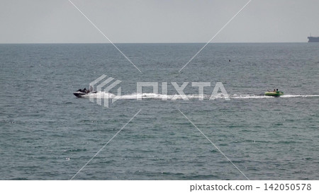 Myskhako Russia July 05 2026 Personal watercraft towing an inflatable tube with people riding over the waves of the Black Sea on a sunny day Myskhako Russia July 05 2026 Personal watercraft towing an inflatable tube with people riding over the waves of the Black Sea on a sunny day 142050578